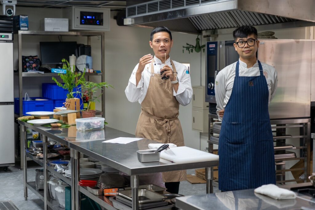 修平科大觀餐系翁淳俞老師（左）與國立高雄餐旅大學廚藝學院葉建志講師（右）共同指導料理製作。（圖：修平科大提供）